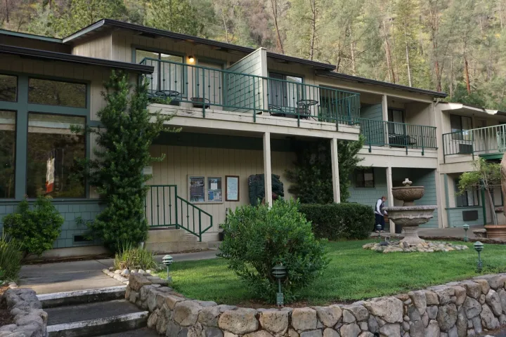 a stone building that has grass in front of a house