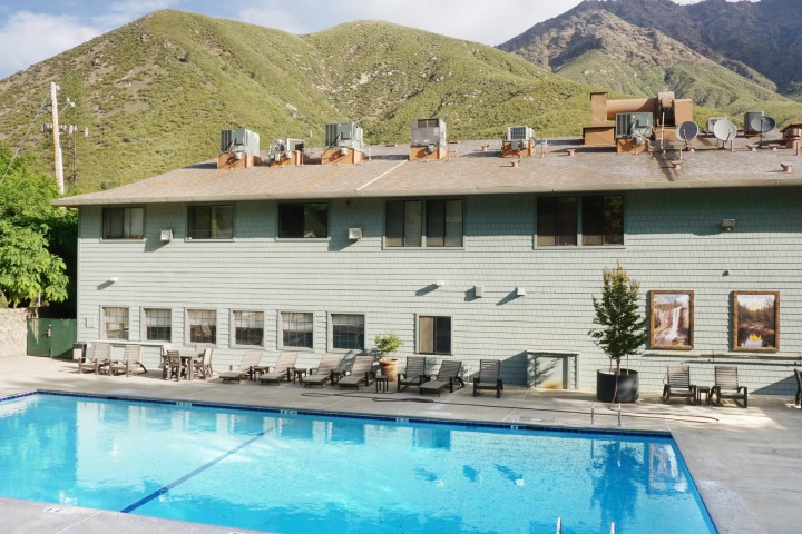 a building with a pool in front of a mountain