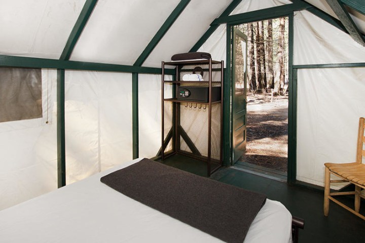 a bedroom with a bed and a chair in a room