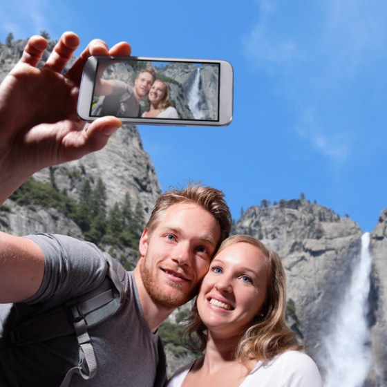 a man and a woman standing in front of a mountain