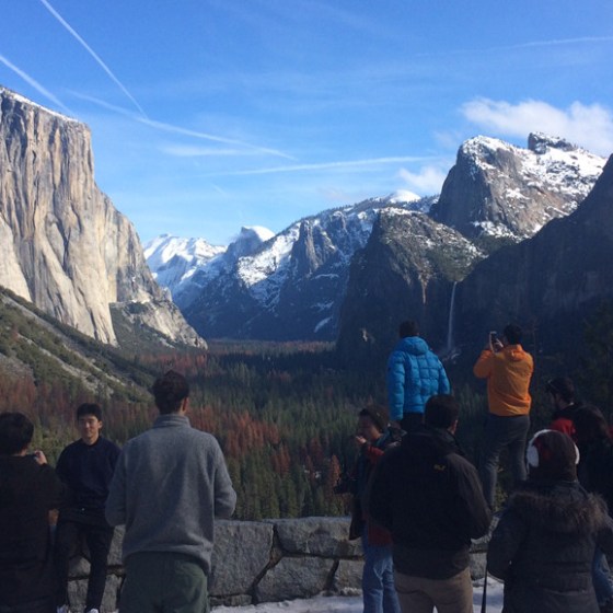 a group of people standing in front of a mountain