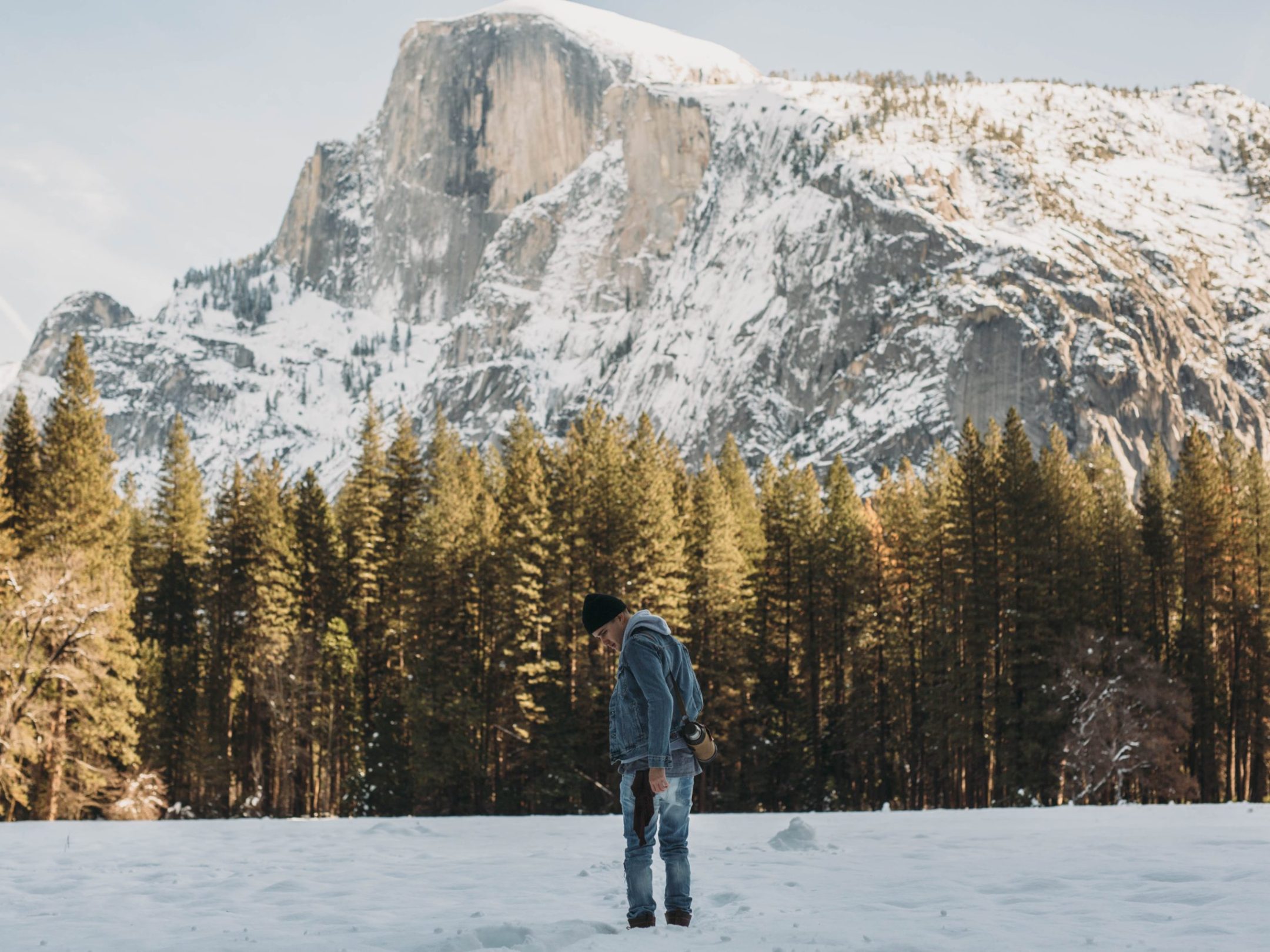 a man standing on top of a snow covered slope