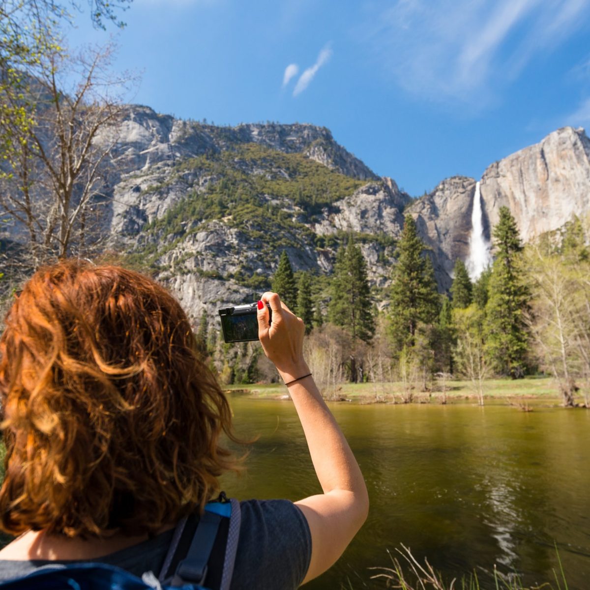 Yosemite valley and waterfalledit a man standing in front of a lake