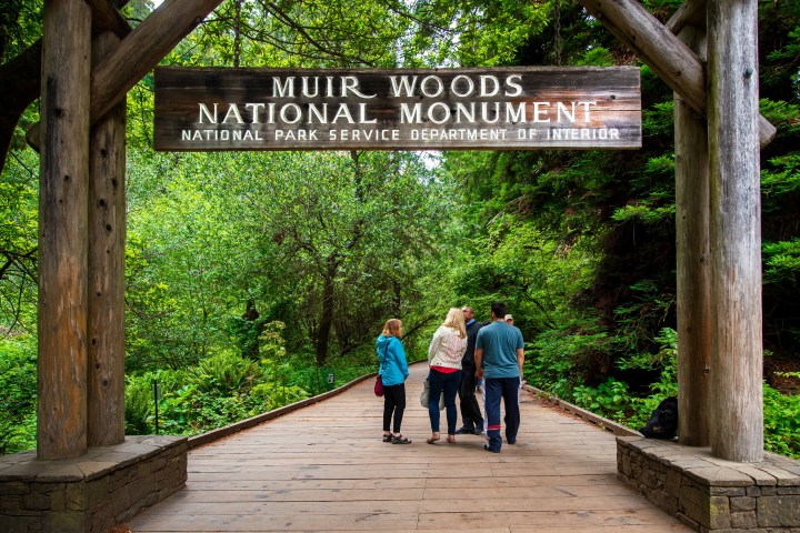 a group of people walking in front of a sign