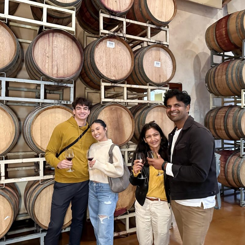 group of people standing in front of a barrel