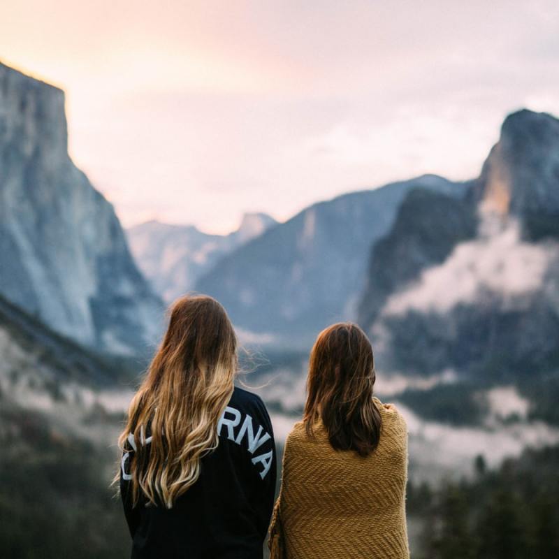 two women standing in front of a mountain